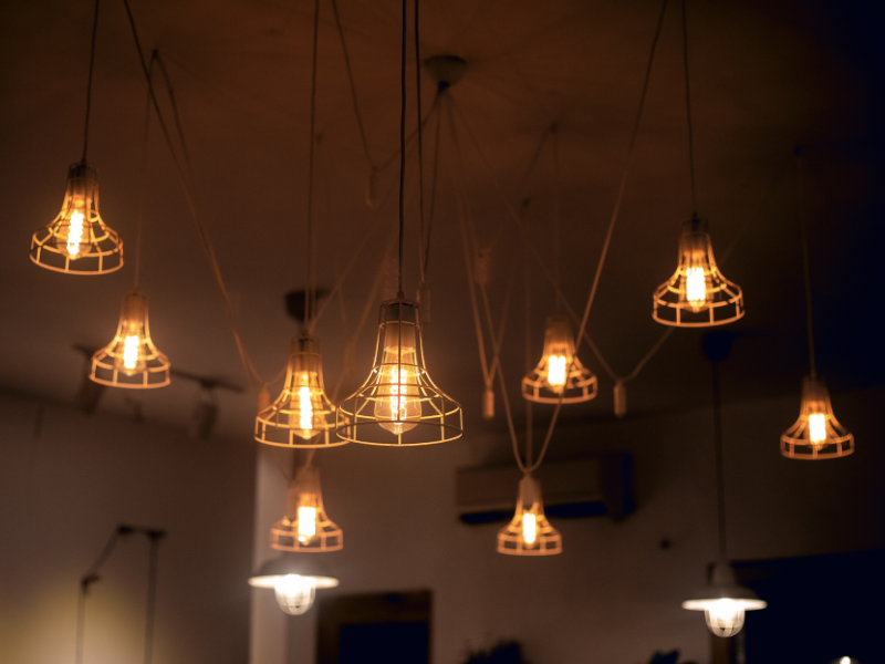 Minimalist beige room with a rounded chair, side table, and potted plant